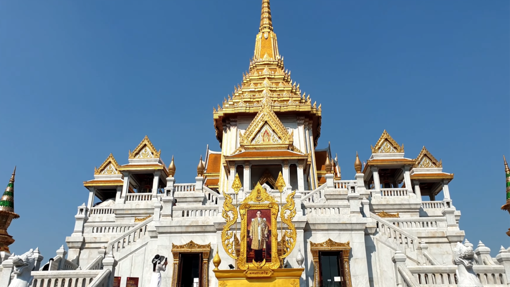 Exterior view of Wat Traimit temple's tiered golden roofs